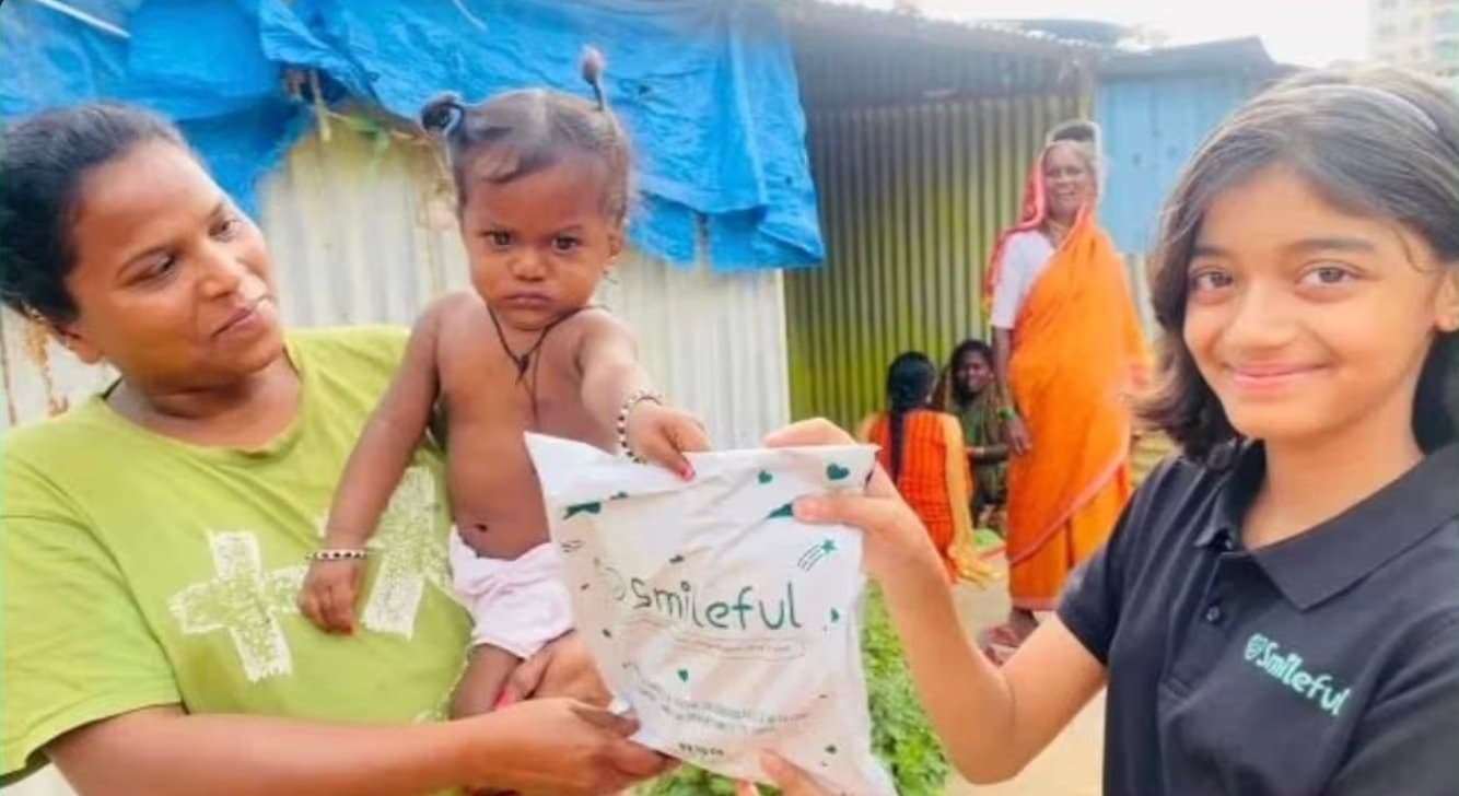 A Smileful volunteer reaching a mother and young child in an underserved community